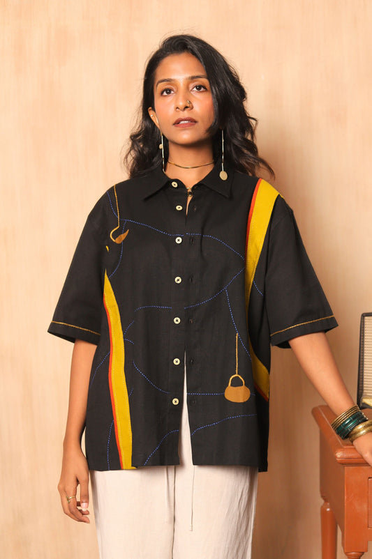 Woman wearing a black and yellow shirt with a vintage radio in the background