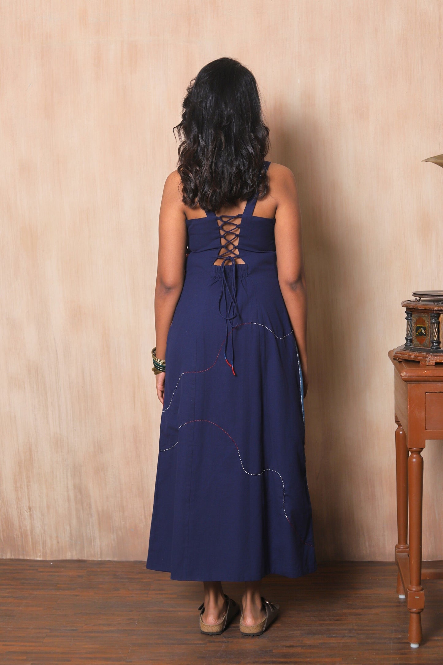 Woman wearing a blue dress with lace-up back.