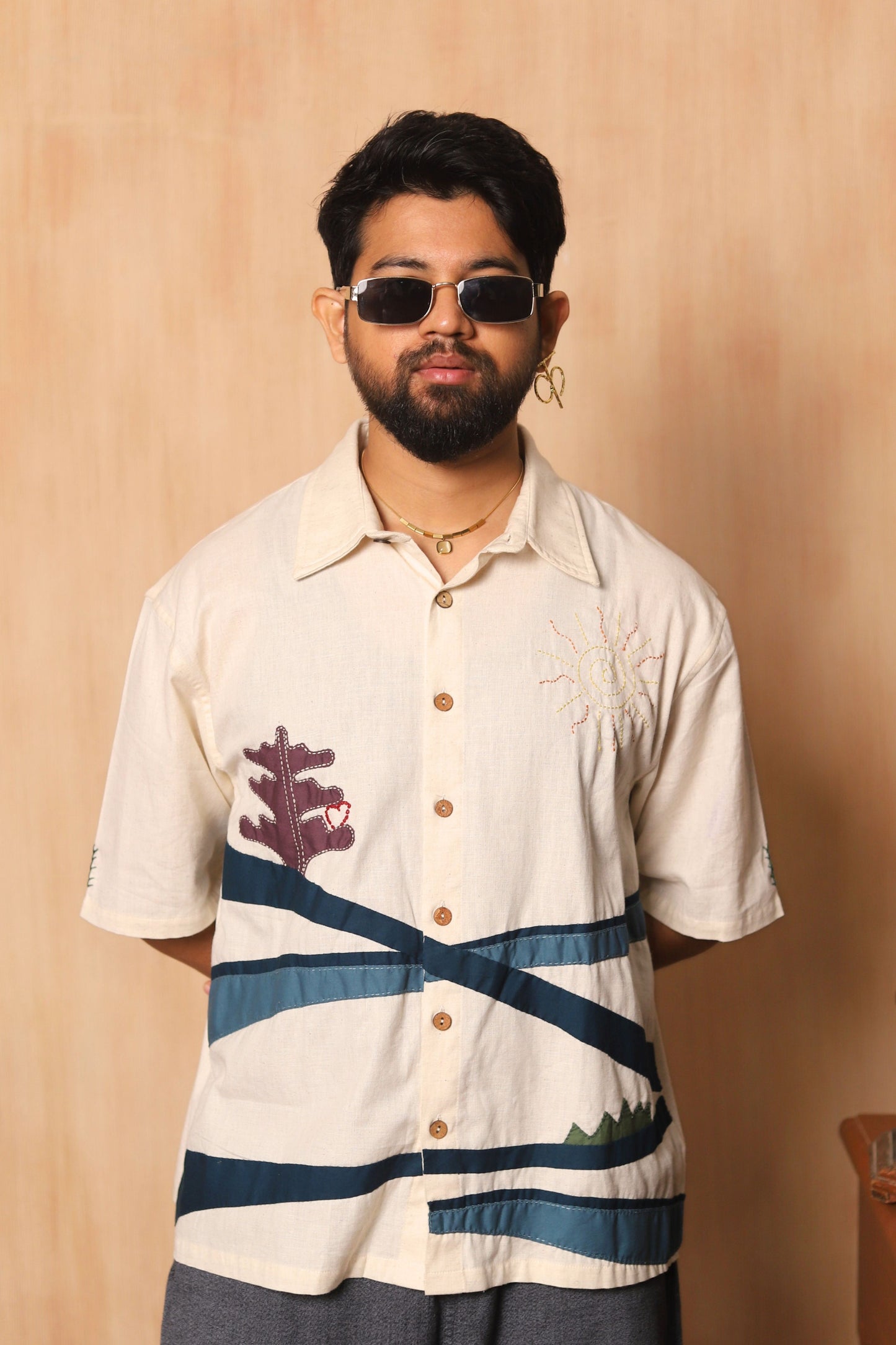 Man wearing a patterned shirt with a beige background