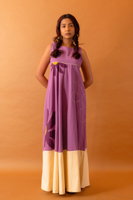 Woman wearing a purple and beige dress against an orange background