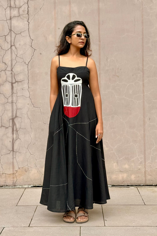 Woman wearing a black dress with a white and red design handwork.